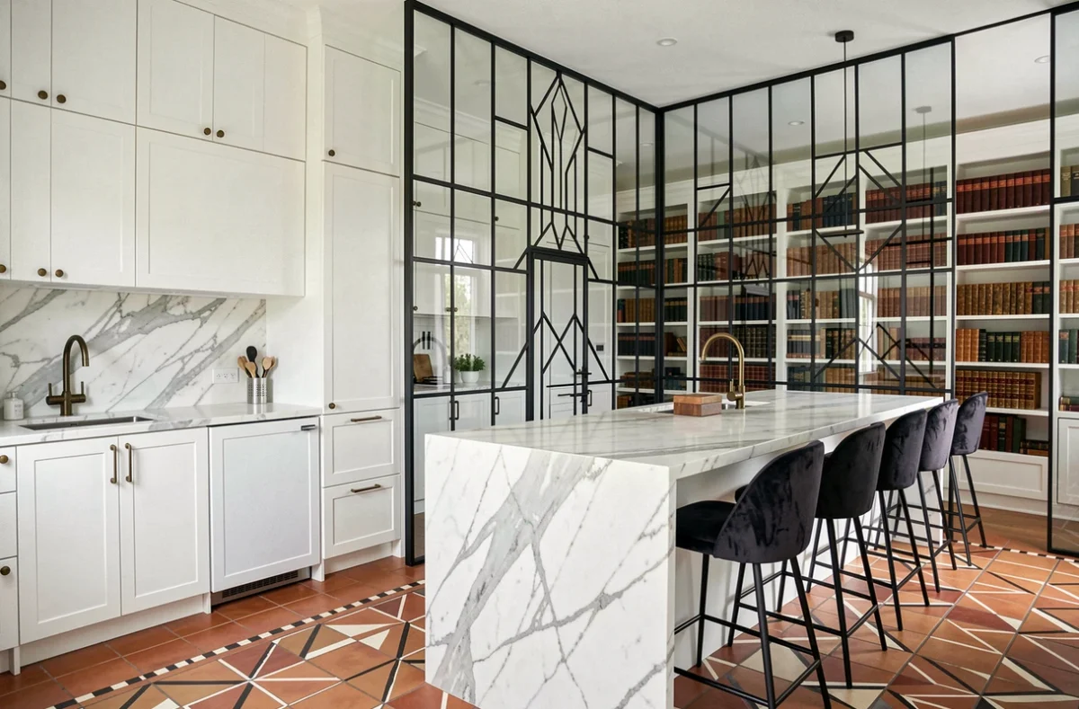 Cuisine contemporaine avec verrière Art Déco noire donnant sur une bibliothèque, plan large avec îlot en marbre